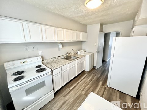 A kitchen with white cabinets and a stove top oven.