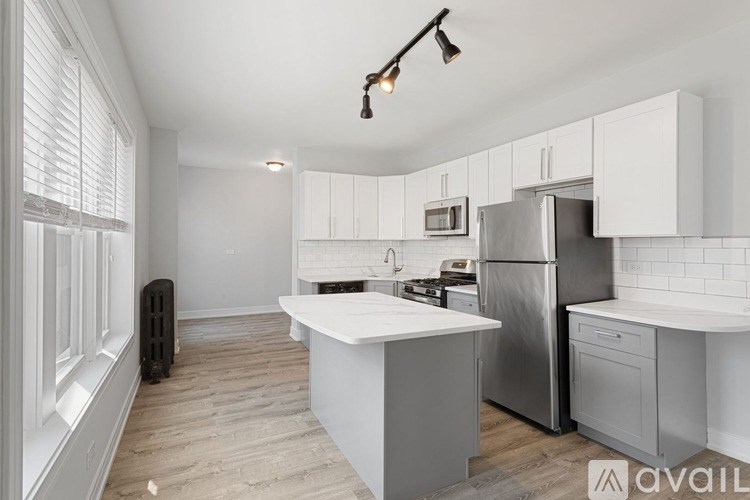 A kitchen with white cabinets and a wooden floor.