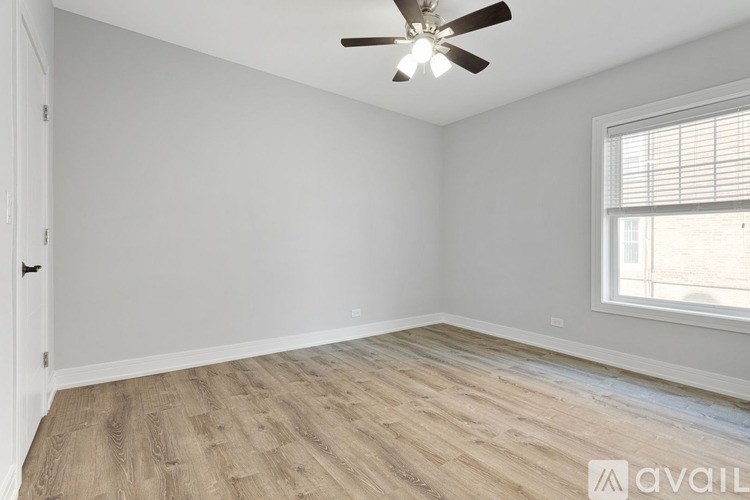 A room with a ceiling fan and a window with blinds.