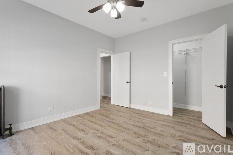 A room with a ceiling fan and wooden flooring.