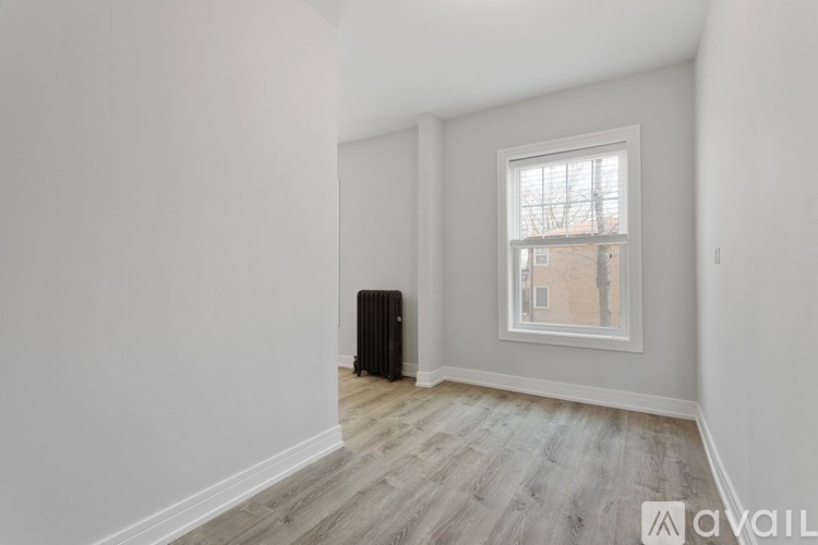 A room with a window and a radiator on the floor.