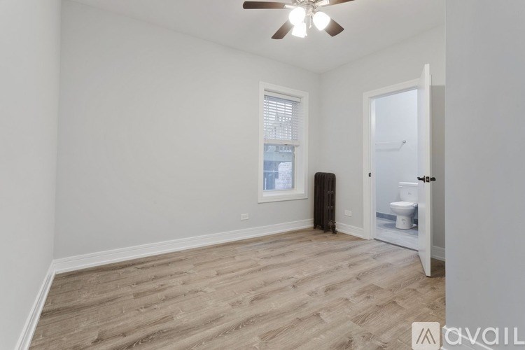 A room with a ceiling fan and a toilet in the corner.