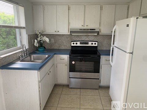 A kitchen with white cabinets and a blue countertop.