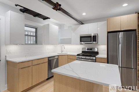 A modern kitchen with wooden cabinets and stainless steel appliances.