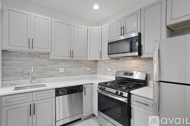A kitchen with white cabinets and stainless steel appliances.