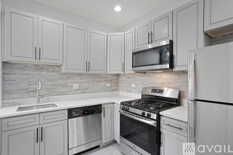 A kitchen with white cabinets and stainless steel appliances.
