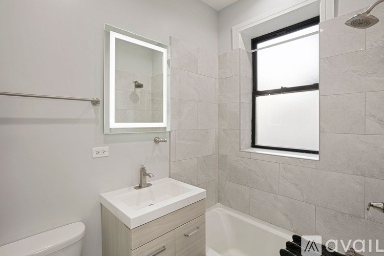 A bathroom with a white sink and a window.