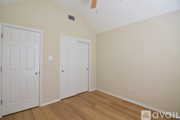 A room with two doors and a ceiling fan.