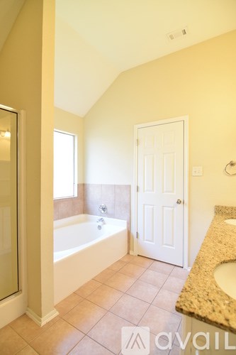 A bathroom with a tub, sink and mirror.