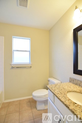 A bathroom with a toilet, sink and window.