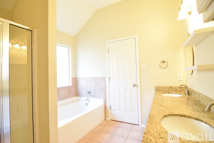 A bathroom with a tub, sink and mirror.