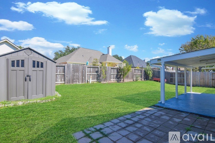 A sunny day at a residential area with houses and a well-maintained lawn.