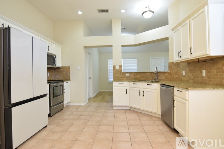 A kitchen with tile flooring and wooden cabinets.