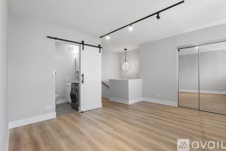 A room with a washing machine and a mirror on the wall.