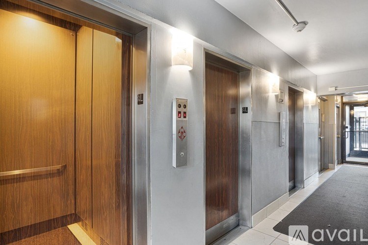 A long hallway with a row of elevators on the right side.