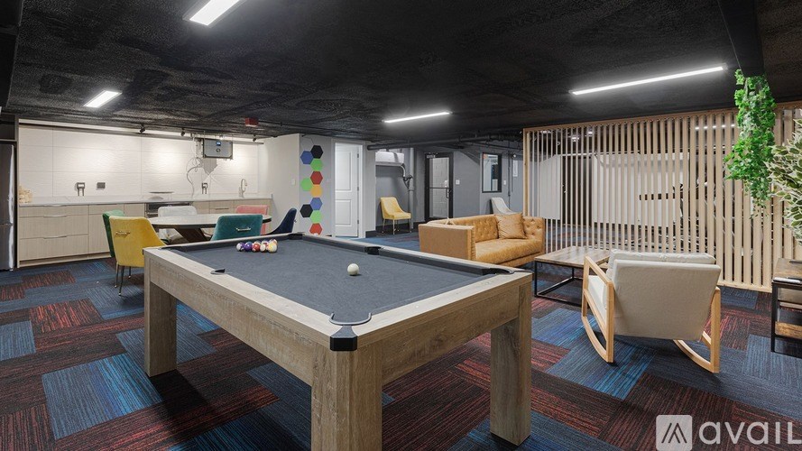 A pool table is in the middle of a room with a wooden floor and a wooden wall.