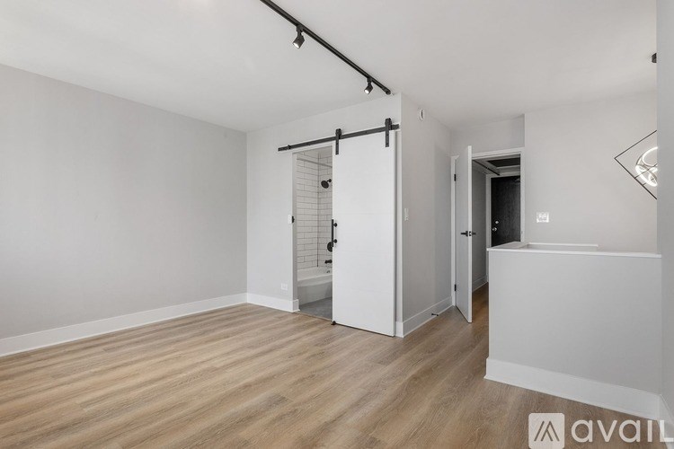 A room with a wooden floor and white walls, with a pull-down bar attached to the ceiling.