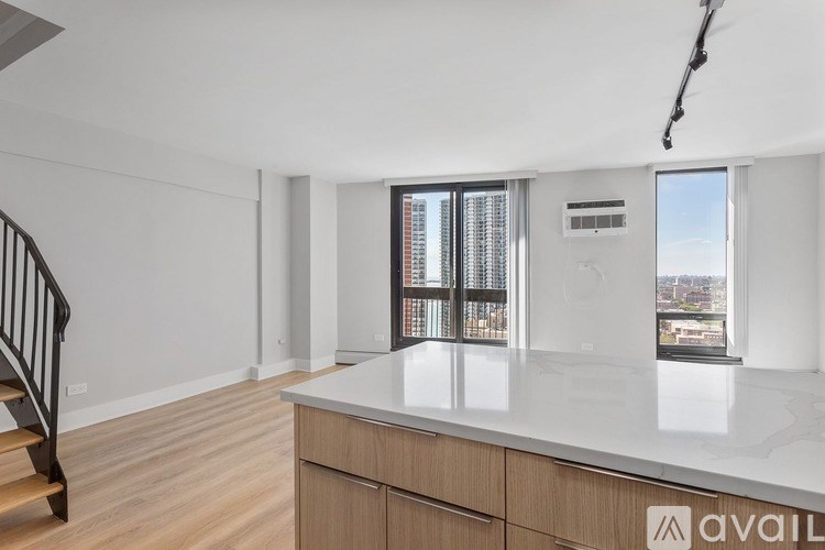 A spacious kitchen with a marble countertop and wooden cabinets.