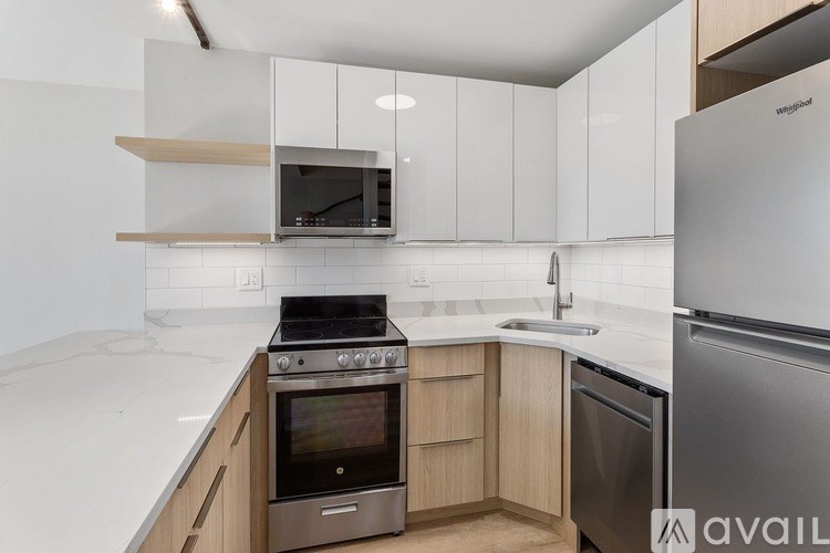 A kitchen with white cabinets and a stainless steel refrigerator.