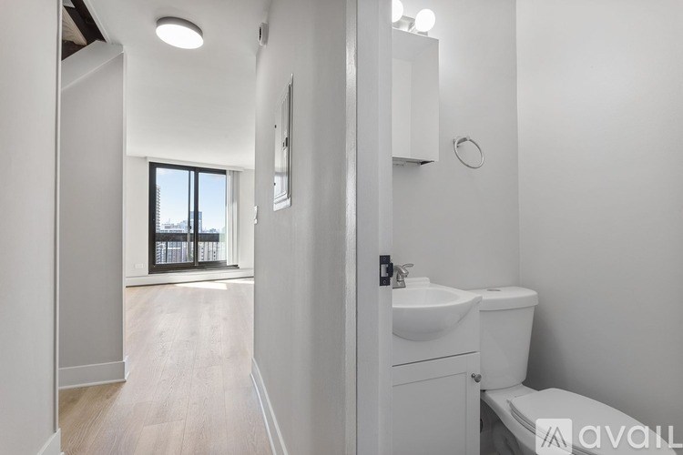 A bathroom with a toilet, sink, and a window.