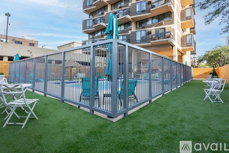 A patio with a table and chairs is surrounded by a metal fence.
