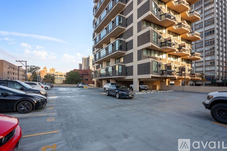 A parking lot with cars and a building in the background.