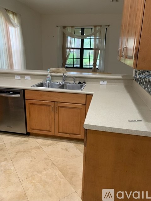 A kitchen with wooden cabinets and a tiled floor.
