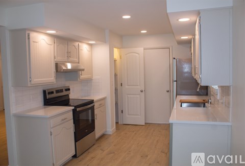 A kitchen with white cabinets and appliances.