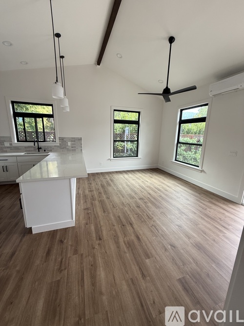 A kitchen with wooden floors and a white countertop.