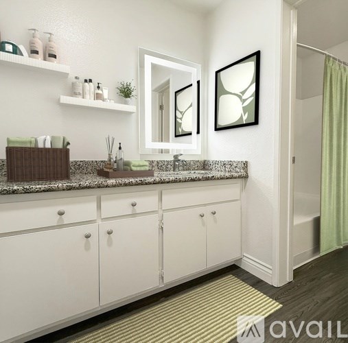 A bathroom with white cabinets and a marble countertop.