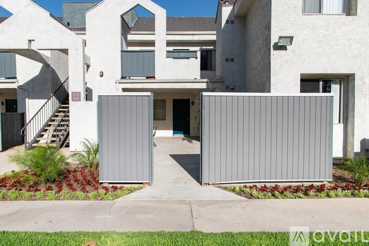 A modern house with a white exterior and a grey gate.