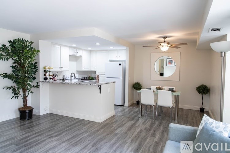 A modern kitchen with a dining area and a living room.