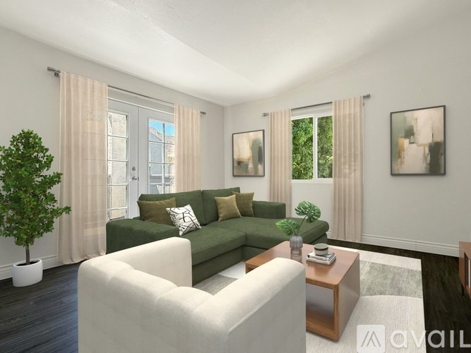 A living room with a green couch, a white armchair, and a wooden coffee table.