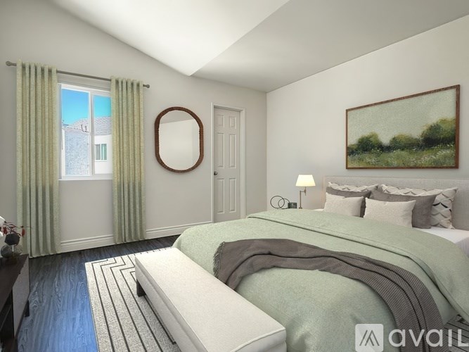 A bedroom with a bed, a window with curtains, a mirror, and a painting on the wall.