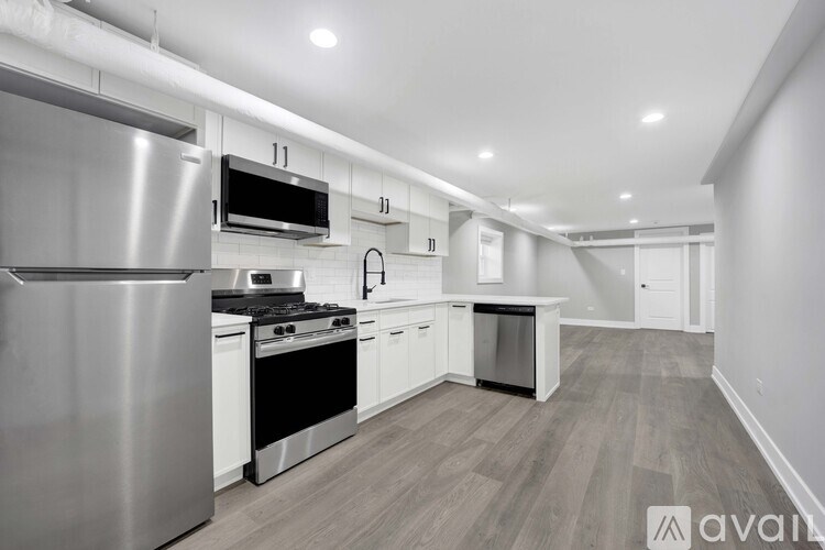 A modern kitchen with stainless steel appliances and white cabinets.