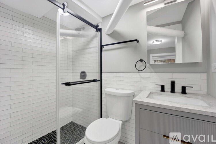 A white toilet in a bathroom with a white tiled wall.