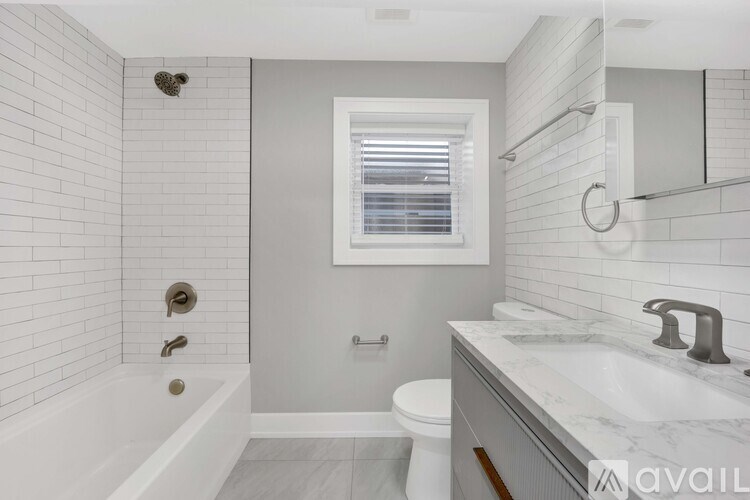 A bathroom with a white tub, toilet, and sink.