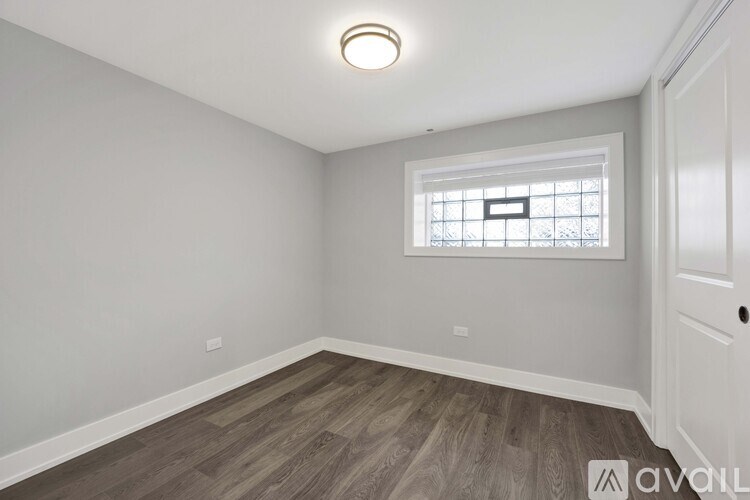 A room with a window and wooden flooring.