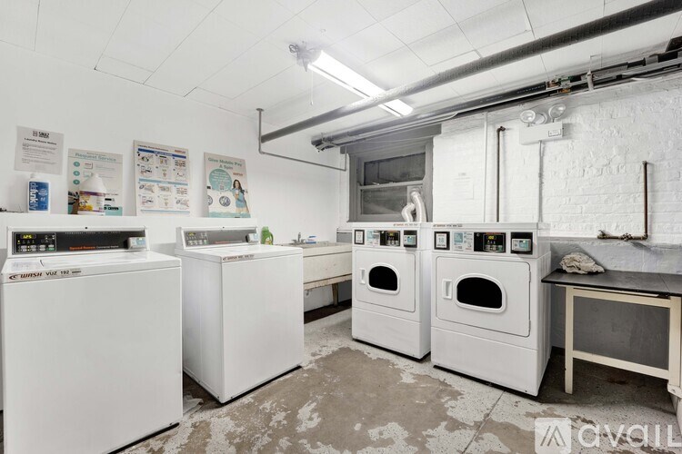 A laundry room with washing machines and dryers.