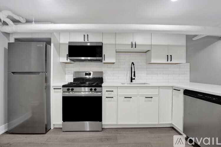 A modern kitchen with stainless steel appliances and white cabinets.