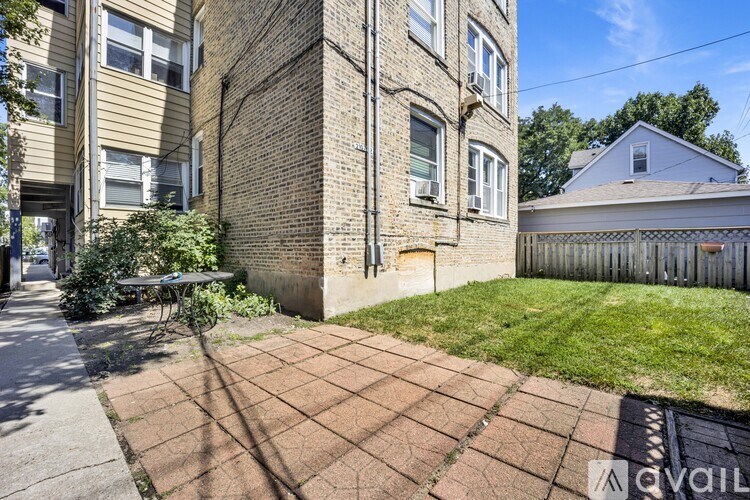 A brick building with a small yard in front.