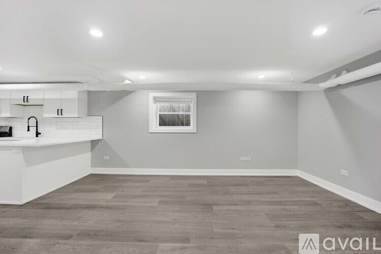A spacious room with grey flooring and white walls.