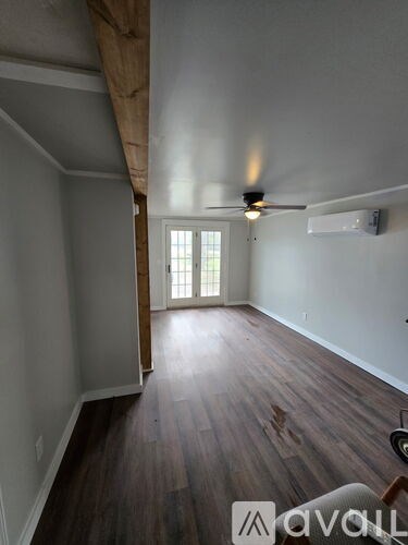 A room with wooden floors and a ceiling fan.