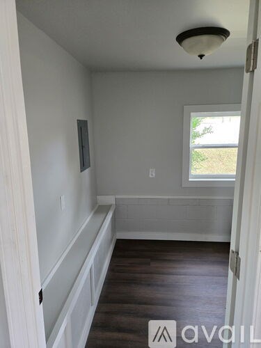 A room with a window and a wooden floor.