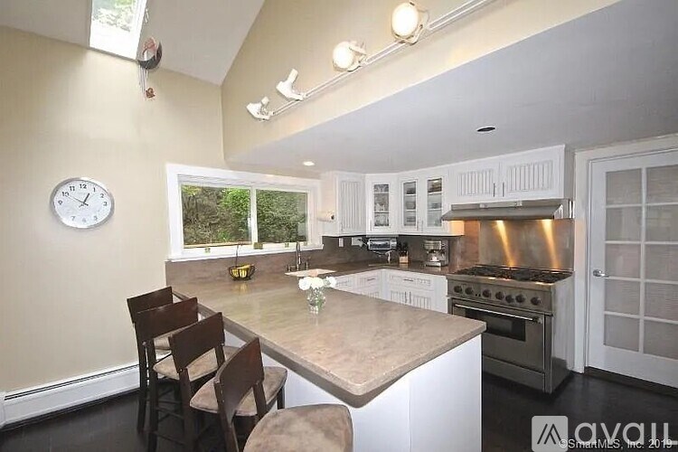 A kitchen with a table and chairs in front of a window.