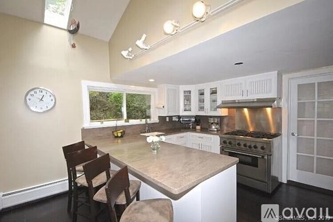 A kitchen with a table and chairs in front of a window.