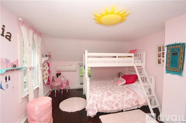 A child's bedroom with a white bunk bed and pink accents.