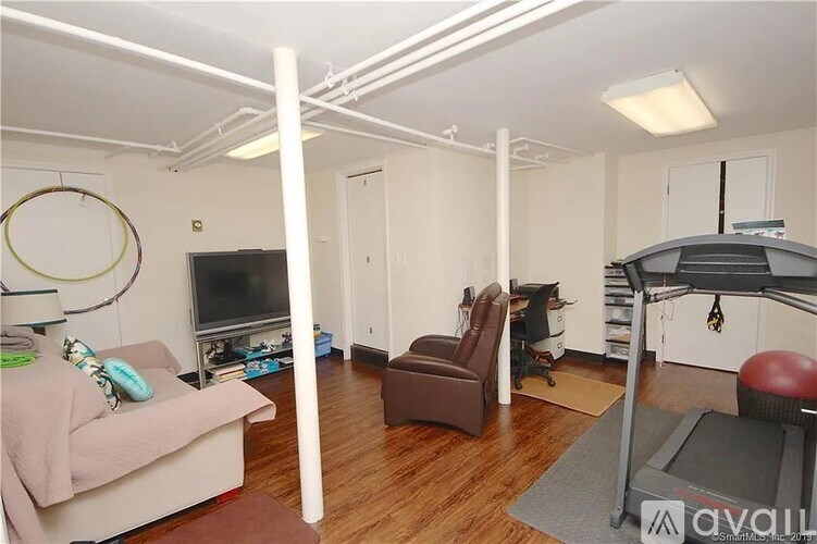 A living room with a couch, chair, and television.