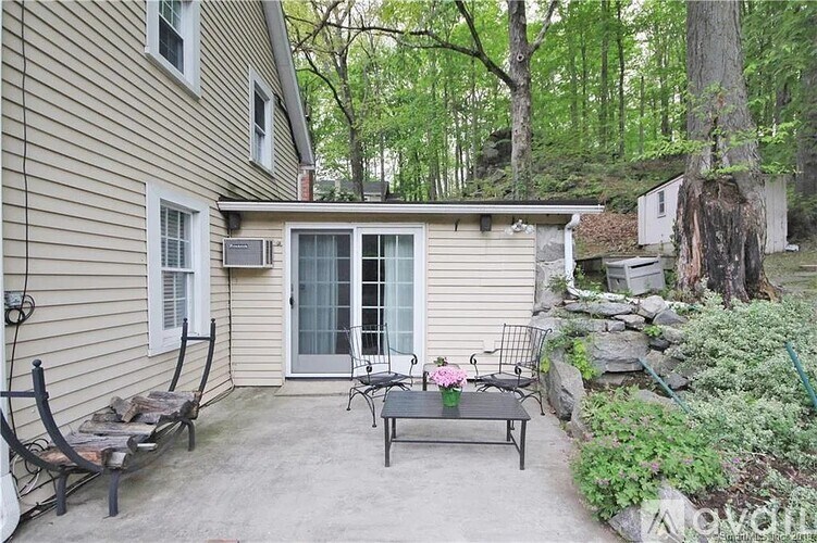 A backyard with a patio, chairs, and a table.
