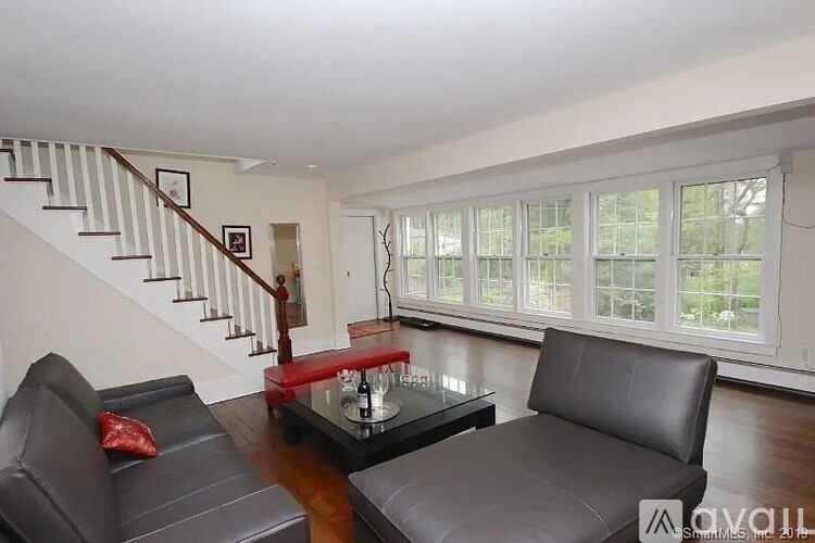 A living room with a black leather couch and a glass coffee table.